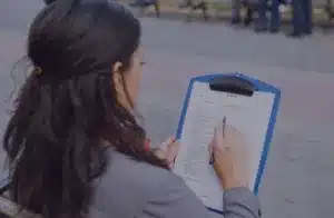 woman-writing-on-notepad-clipboard-eclive